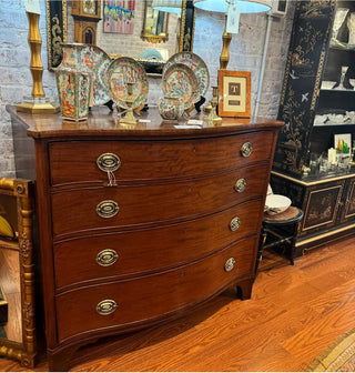 Wooden dresser with decorative items in a room with brick walls and other furniture.