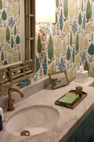 Bathroom vanity with floral wallpaper, sink, and decorative items.